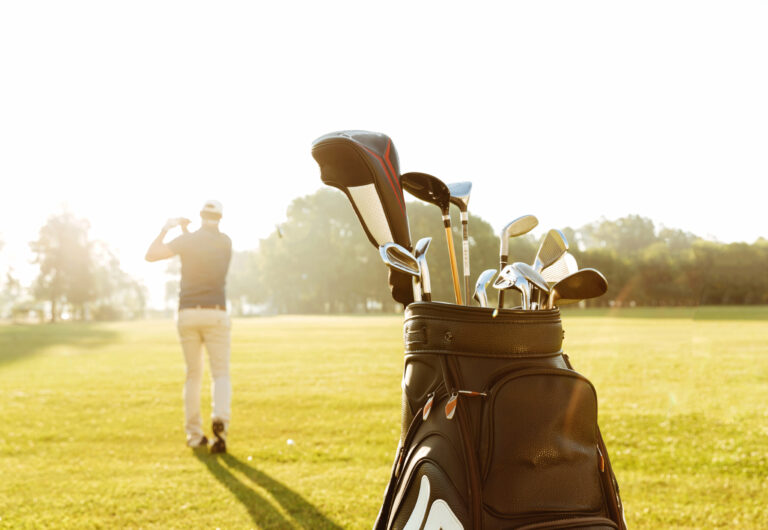 Back view of a male golfer swinging golf club stay and play golf packages