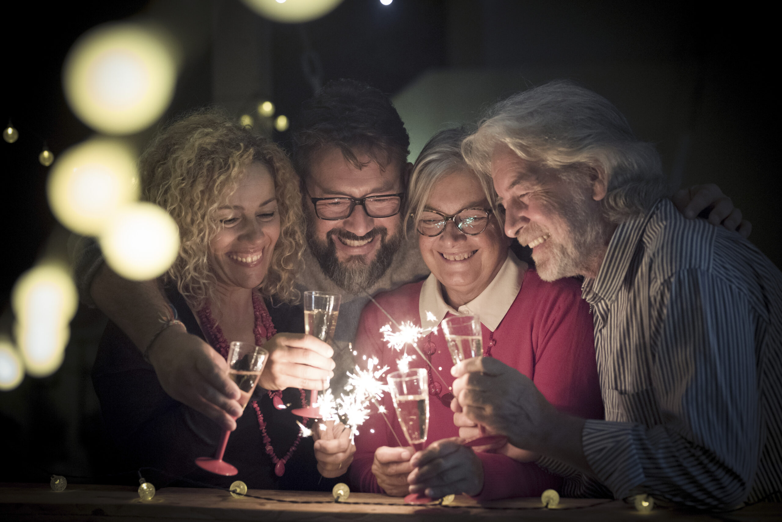 Emailer 1 group two seniors two adults together having fun with sparlers new year celebrate happy family with lights midnight scaled